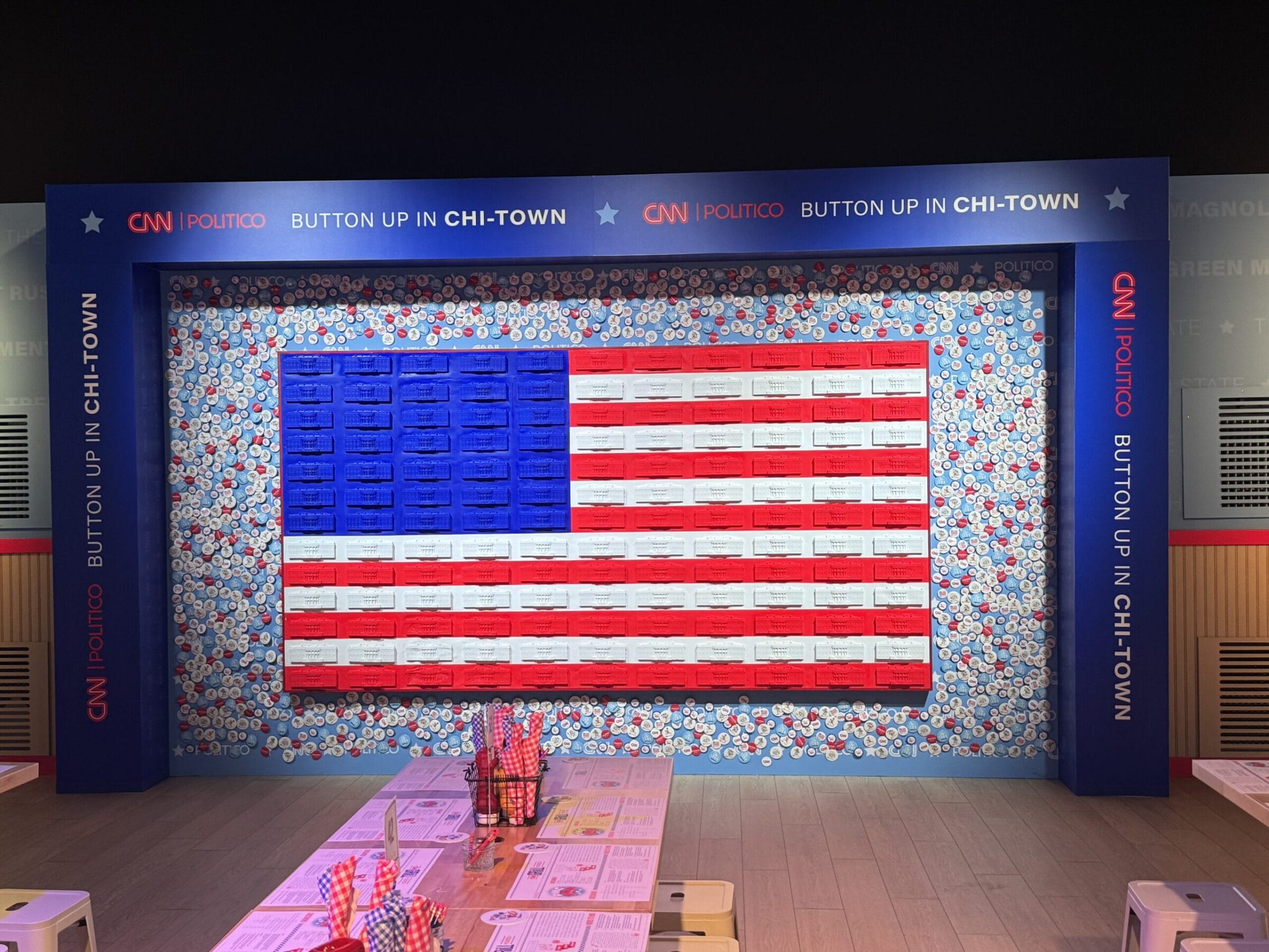 American flag made of buttons and boxes, framed by "CNN POLITICO BUTTON UP IN CHI-TOWN" signage.