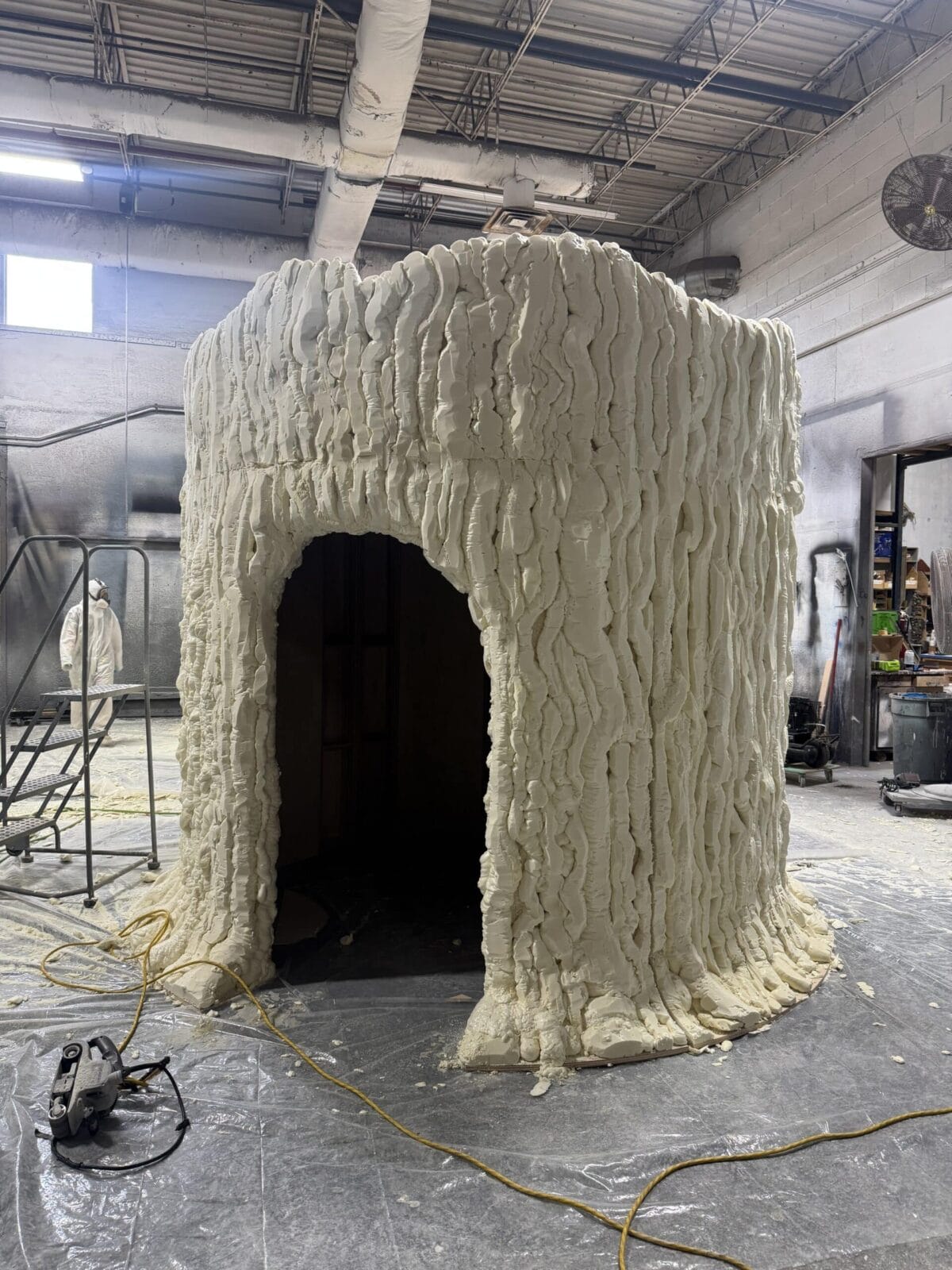 Textured foam structure with arched entrance in workshop.