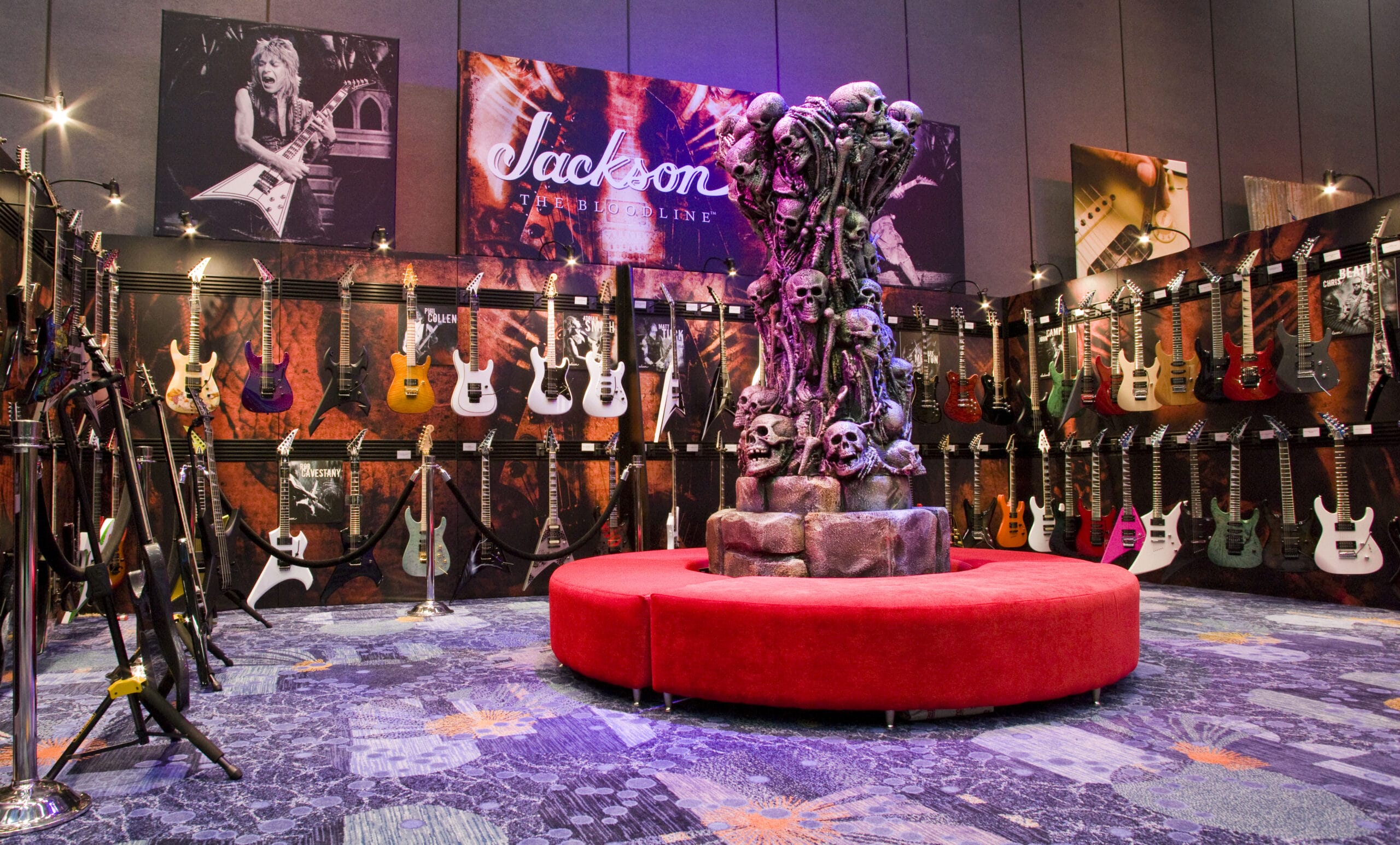 Jackson guitars displayed around a skull sculpture and red seating.