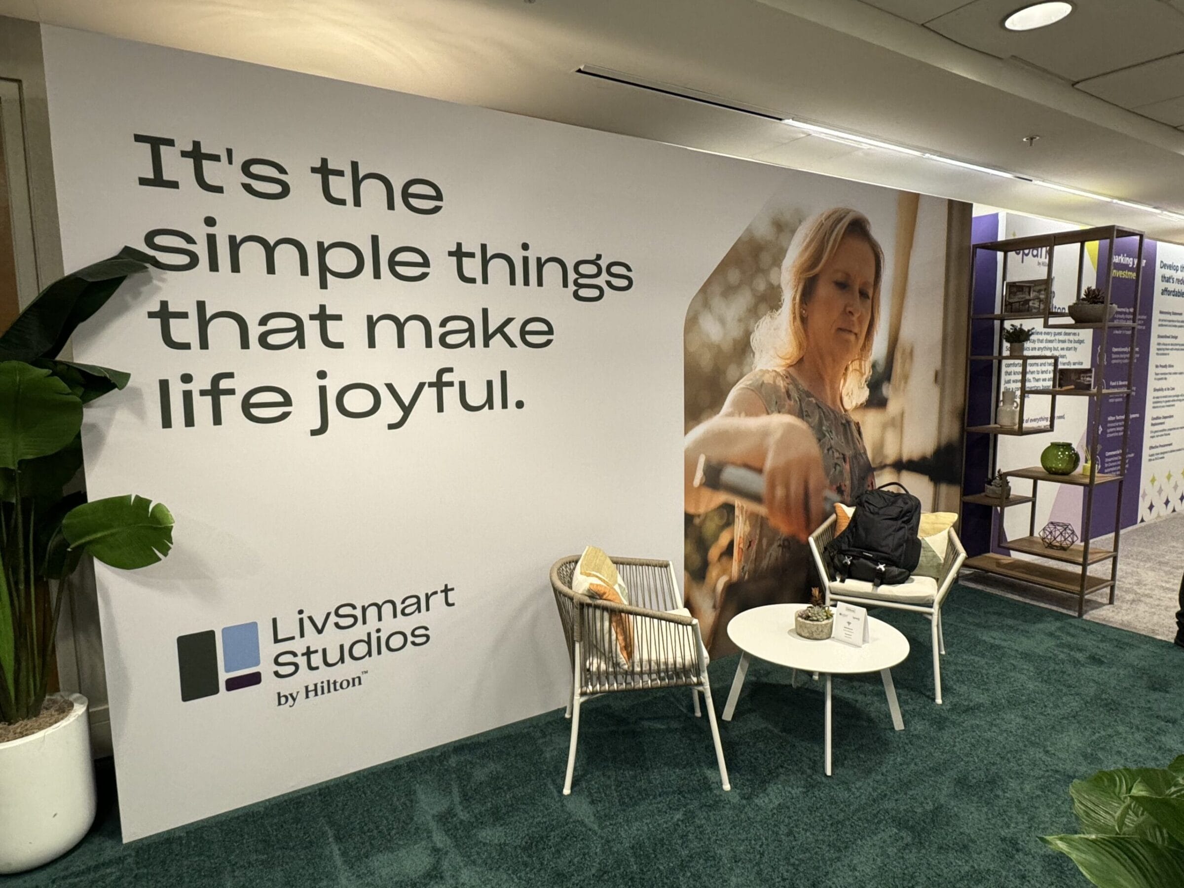 LivSmart Studios by Hilton banner with inspirational quote and woman's portrait.
