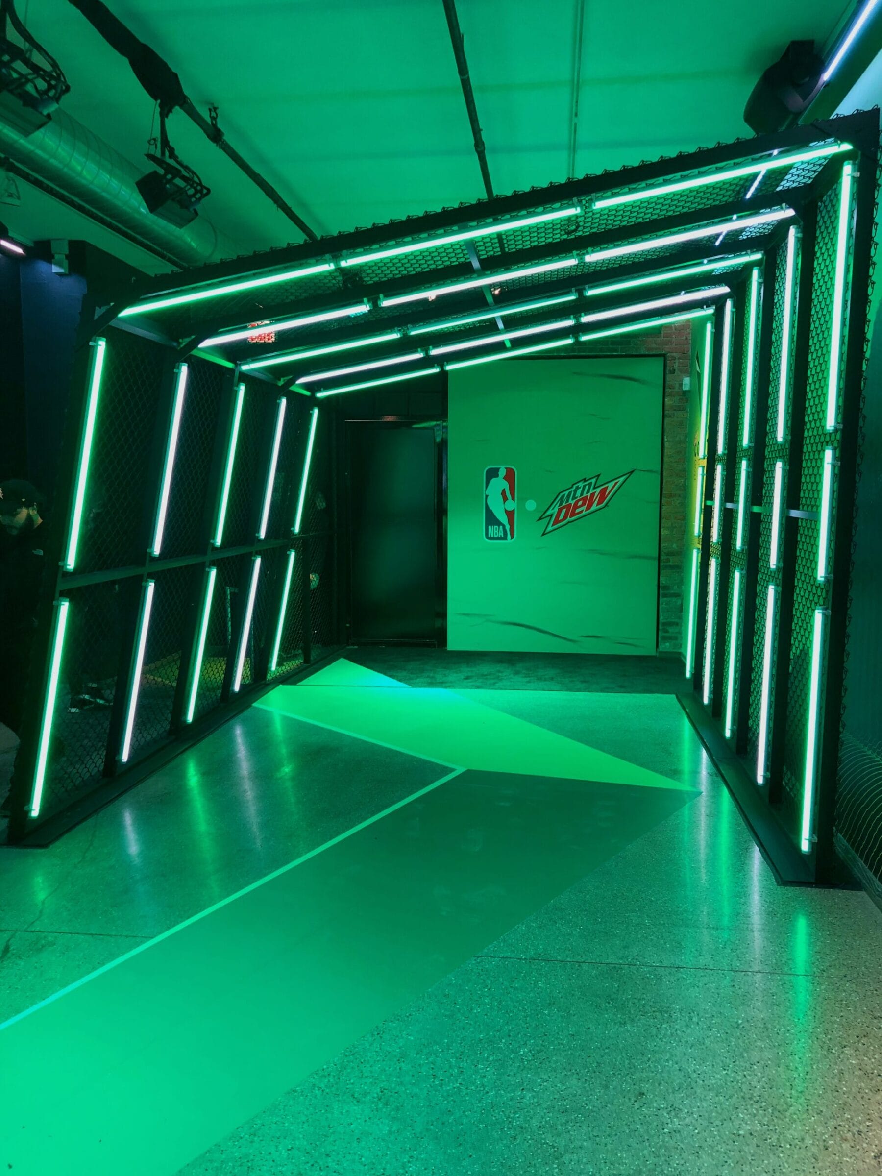 Green neon-lit tunnel with NBA and Mountain Dew logos.