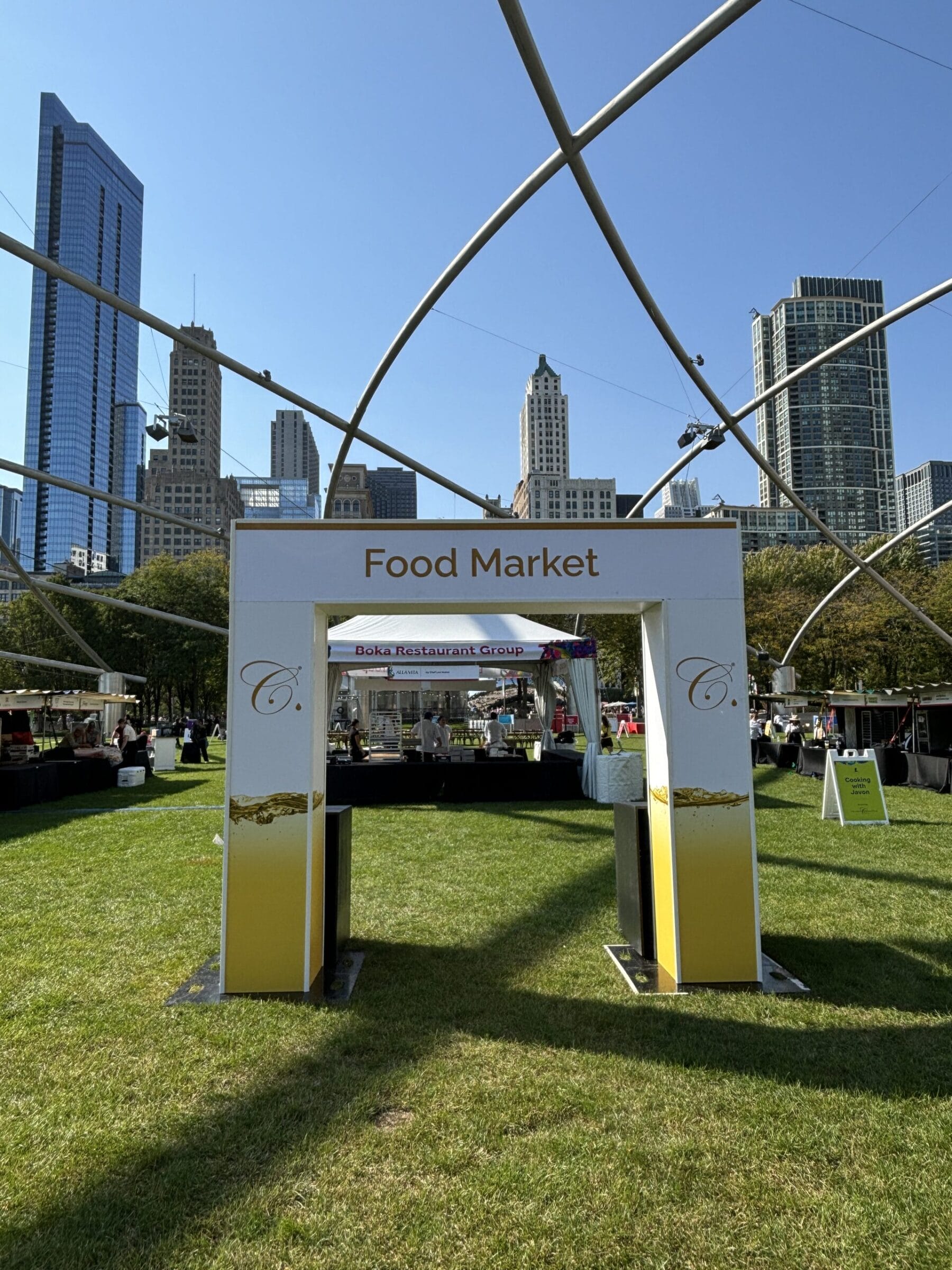 Food Market entrance with Chicago skyline and tents in background.