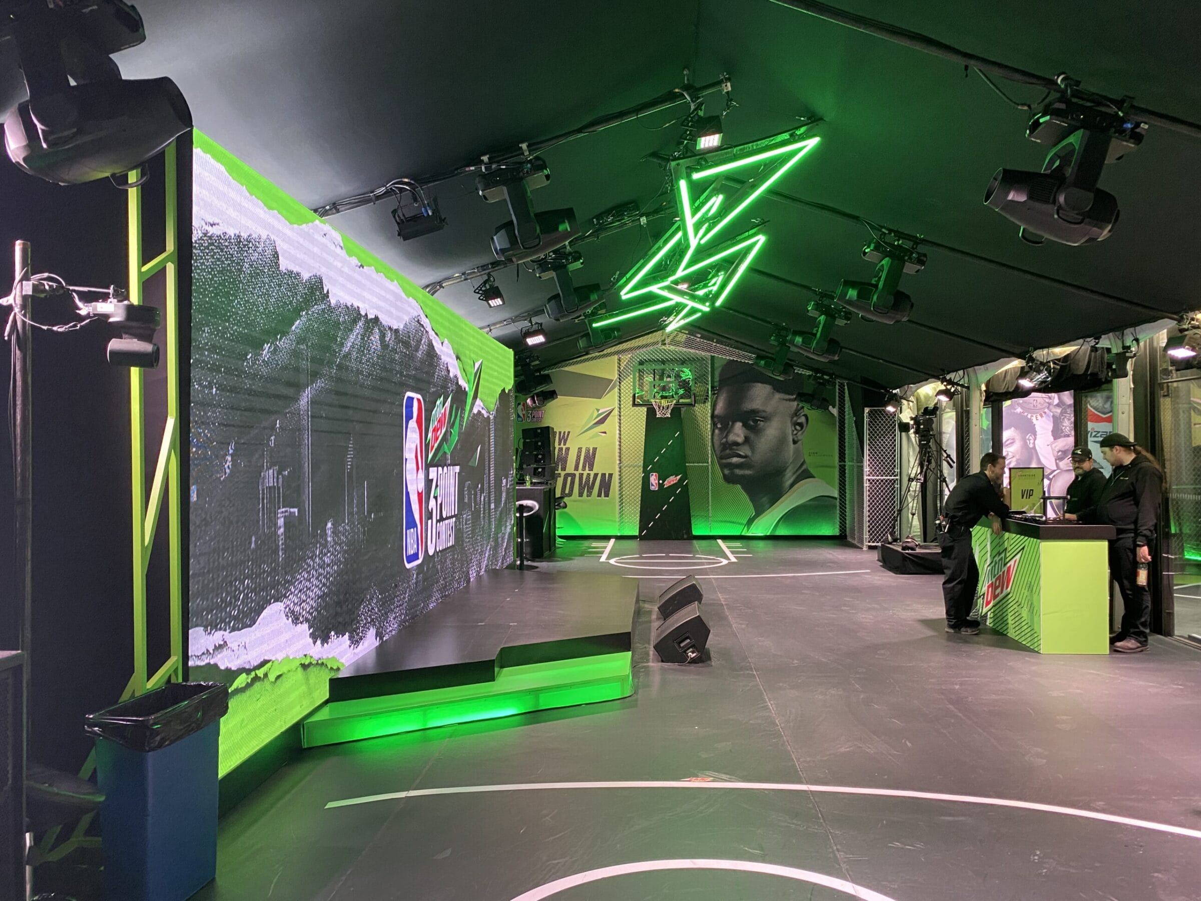 Mountain Dew NBA 3-Point Contest event setup with basketball court, large screen, and neon lighting.
