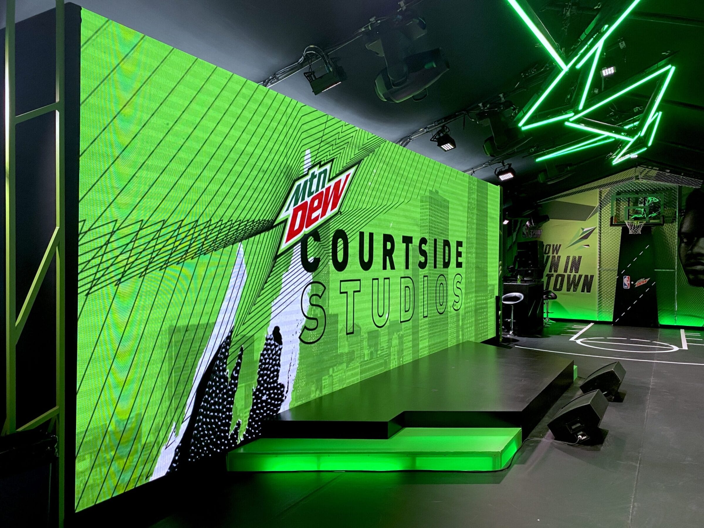 Mtn Dew Courstside Studios with basketball court backdrop and green neon lights.