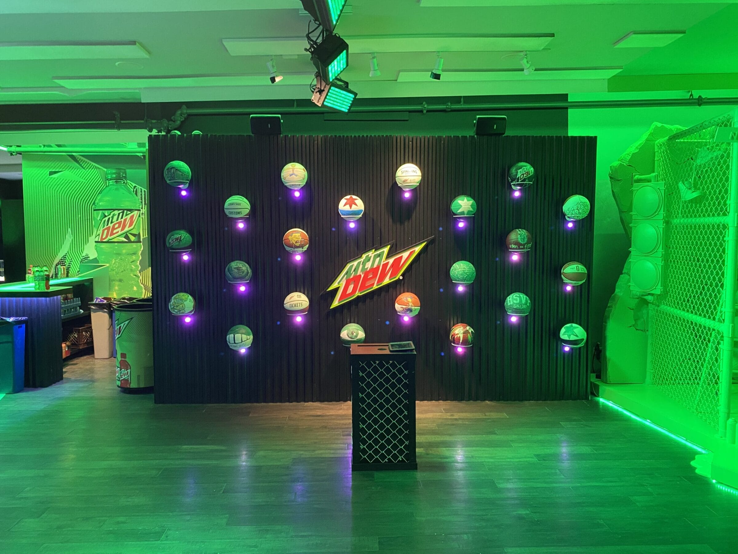 Mountain Dew display with helmets on a wall and a large bottle graphic.