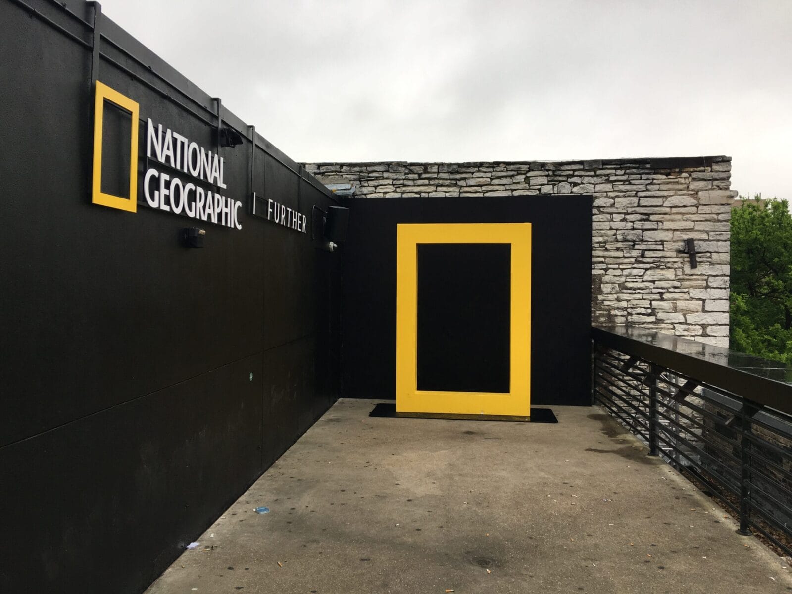 National Geographic logo and a large yellow frame on a black wall.