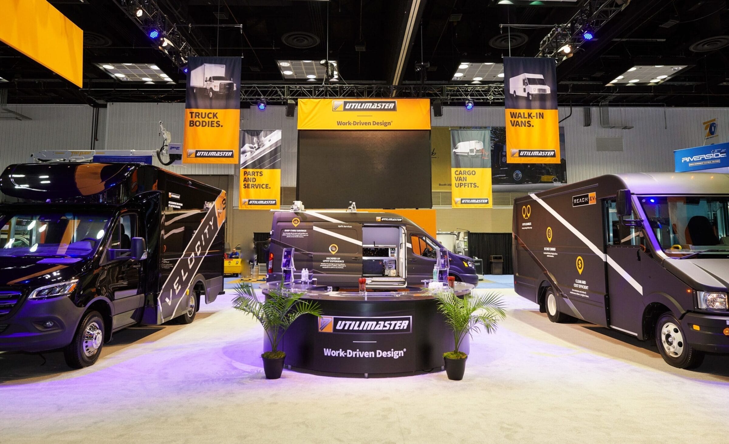 Utilimaster display with vans, banners for truck bodies, parts, service, and walk-in vans.
